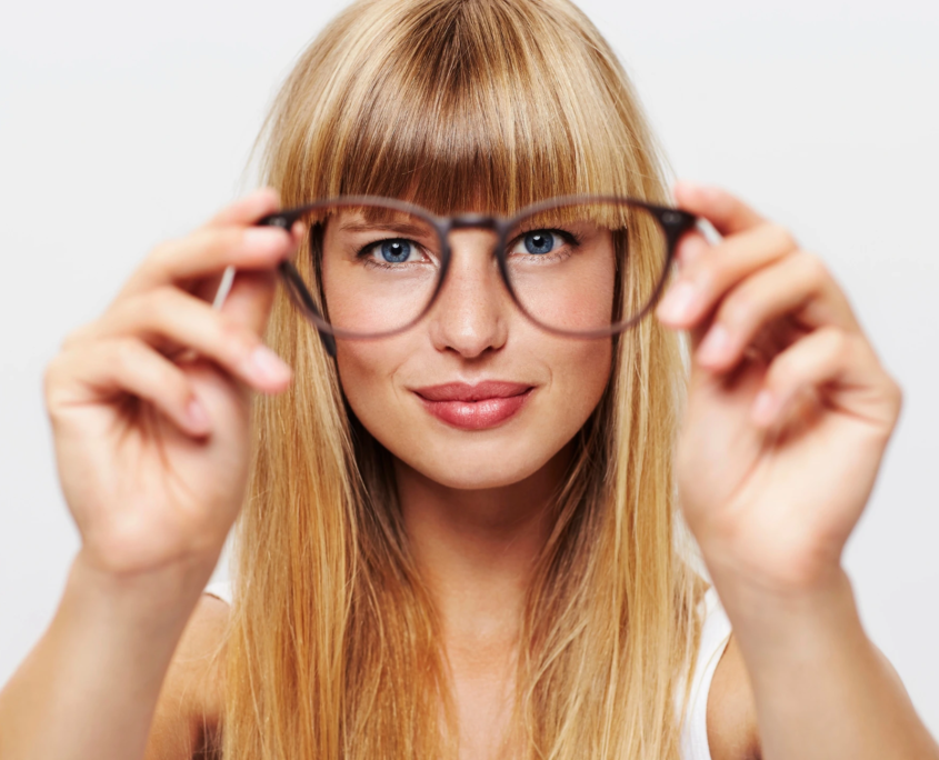 Frau mit blonden Haaren und Brille.
