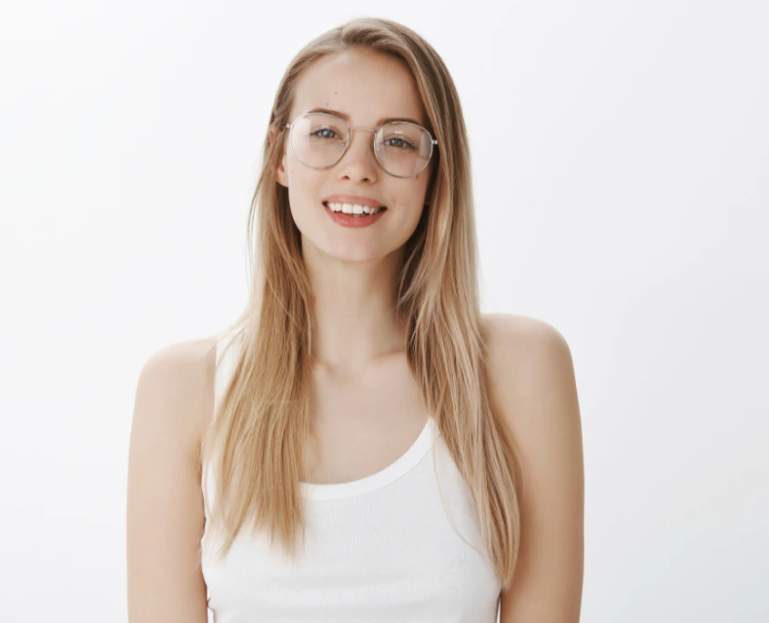 Frau mit blonden Haaren und einer Korrektionsbrille.