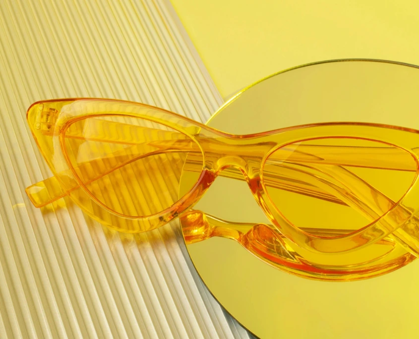 Gelbe Sonnenbrille vor einem gelben Hintergrund.